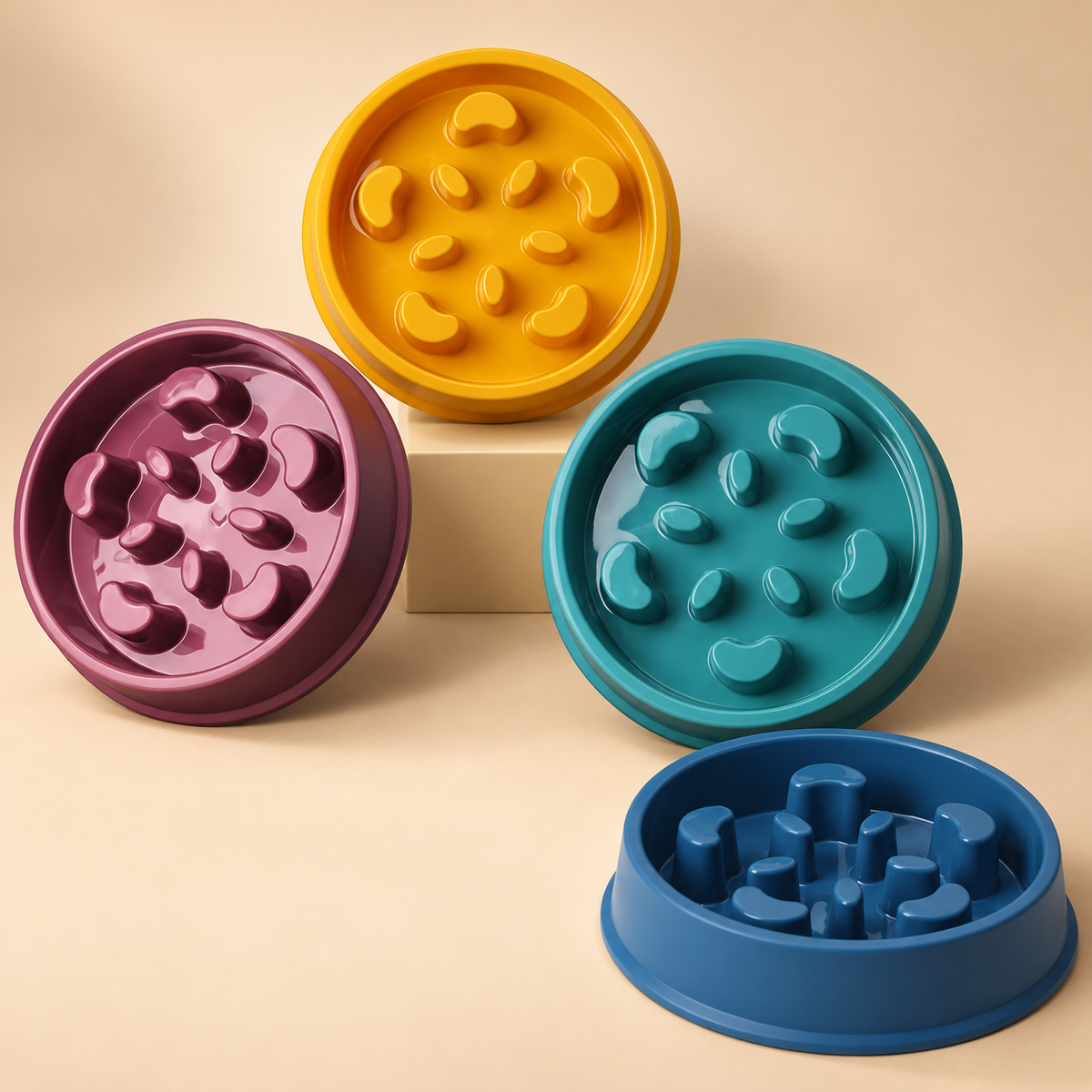 Colourful slow-feeding pet bowls on warm beige background